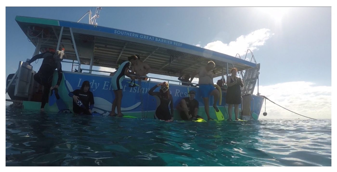 Sitting on the side of the boat ready to snorkel